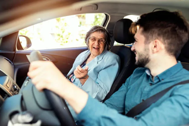 Senior woman smiling with her caregiver in the car